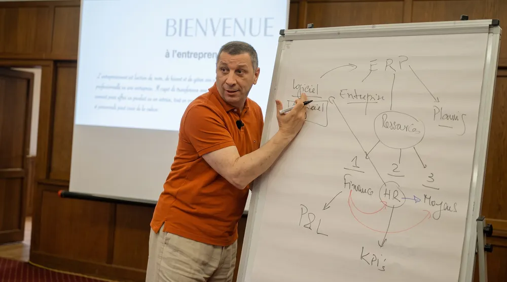 Un expert Labeeb explique un sujet devant un paperboard
