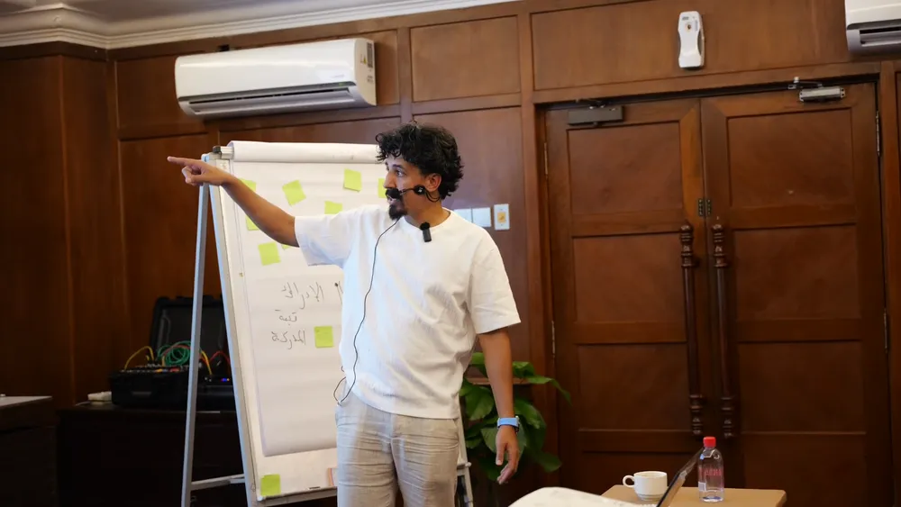 Un formateur présente un sujet devant un paperboard
